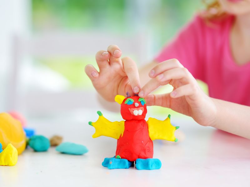 50+ trò chơi phát triển tư duy cho trẻ mầm non từ 3 - 5 tuổi 19 Bé nhào đất nặn một cách thành thạo.