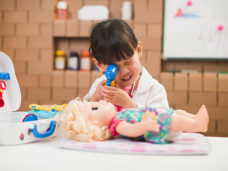 50+ trò chơi phát triển tư duy cho trẻ mầm non từ 3 - 5 tuổi 35 Bé giả làm bác sĩ và khám cho “bệnh nhân” búp bê.